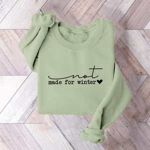 Detail of sage green sweatshirt with black not made for winter slogan and heart print
