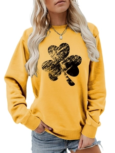 Close-up of ribbed cuffs and black clover print on a bright yellow crewneck sweatshirt