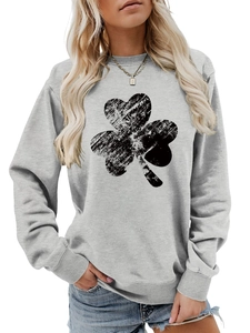 Close-up of a light grey crewneck sweatshirt featuring a distressed black clover print