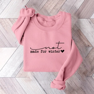 Detailed flat lay of pink fleece sweatshirt with black Not Made For Winter slogan