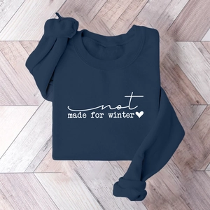 Flat lay of navy blue crewneck sweatshirt with white not made for winter lettering