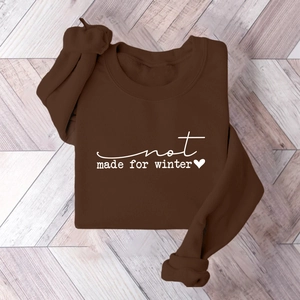Close-up of thick fleece sweatshirt with not made for winter print on grey floor