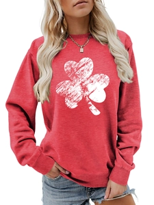 Close-up of red long sleeve sweatshirt featuring a distressed white clover print