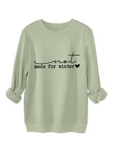 Close-up of sage green fleece sweatshirt with Not Made For Winter print and ribbed cuffs