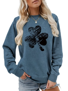 Detail of teal crewneck sweatshirt featuring a black vintage clover print and ribbed cuffs