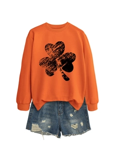 Flat lay detail of orange shamrock sweatshirt and distressed denim shorts outfit set