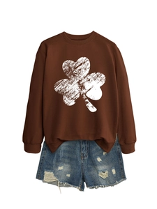 Detailed shot of dark coffee sweatshirt with white shamrock print and distressed denim shorts