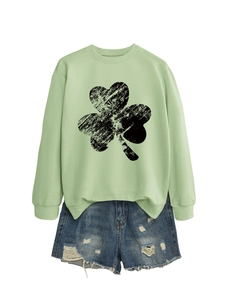Flat lay of light green clover sweatshirt with distressed shorts on white background