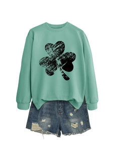 Detail of mint green sweatshirt with clover print and distressed denim shorts