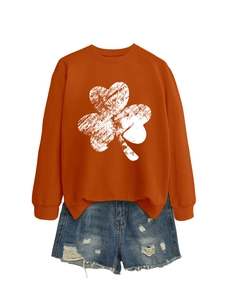 Detail of orange crewneck clover sweatshirt with distressed white print and denim shorts