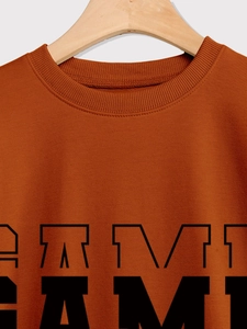 Detail of caramel crewneck sweatshirt featuring ribbed collar and black AMI lettering