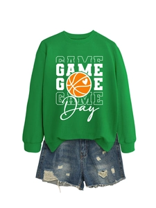Flat lay of green Game Day basketball sweatshirt paired with distressed denim shorts