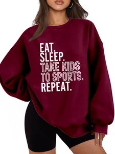 Detail of Eat Sleep Take Kids slogan print on burgundy fleece oversized sweatshirt