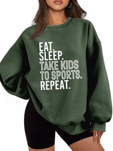Detail of loose dark green sweatshirt with ribbed cuffs and white letter slogan print