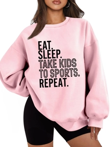 Detail of pink oversized sweatshirt featuring black Eat Sleep Take Kids To Sports slogan