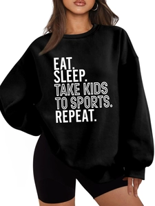 Detail of Eat Sleep Take Kids slogan print on loose black fleece sweatshirt