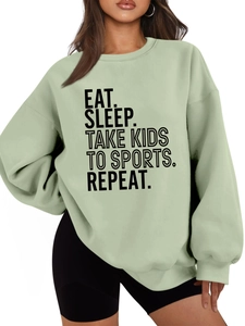 Detail of light green drop-shoulder hoodie with Eat Sleep Take Kids slogan print