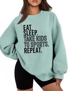 Close-up of Mint Green sweatshirt featuring EAT SLEEP TAKE KIDS TO SPORTS printed text