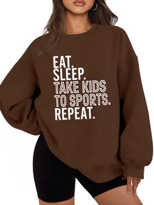 Detail of Eat Sleep Take Kids To Sports slogan on a loose dark brown fleece hoodie