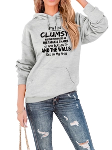 Detail of light gray hoodie with black slogan print, drawstring hood, and front pocket