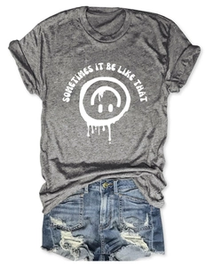 Mise à plat d'un t-shirt gris avec graphique sourire et short en jean bleu usé
