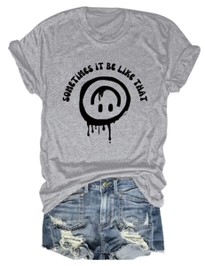 Mise à plat d'un t-shirt gris avec texte graphique et un short en jean bleu déchiré