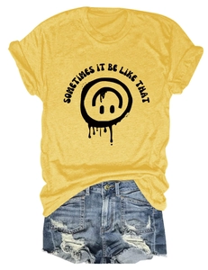 Détail du t-shirt jaune avec graphique sourire et short en jean bleu délavé