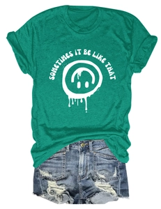 Détail du t-shirt vert forêt avec imprimé smile blanc et short en jean vieilli