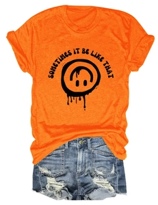 Mise à plat d'un t-shirt orange avec imprimé sourire et short en jean délavé