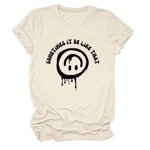 Détail du motif smiley graffiti et texte sur un t-shirt en coton crème à col rond