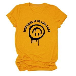Détail d'un t-shirt en coton jaune moutarde avec un smiley noir et une impression texte