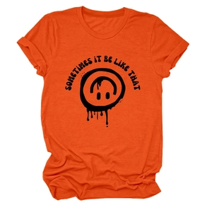 Détail du t-shirt en coton orange avec un smiley fondant et texte de slogan