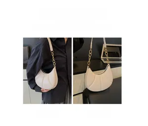 Minimalist beige crescent shoulder bag with golden chain detail for versatile styling