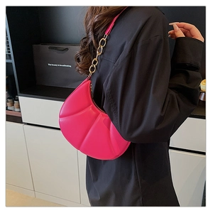 Detail of fuchsia shell-pleated shoulder bag with gold chain strap and zipper closure