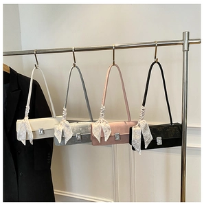 Detail of elegant shoulder bags with polka dot scarves and artistic silver square clasps