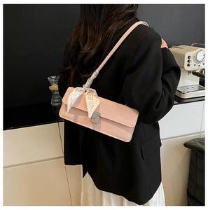 Detailed view of pink leather shoulder bag with decorative silk scarf and silver buckle