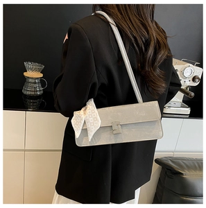 Close-up of light grey shoulder bag with silk scarf and crystal square buckle detail