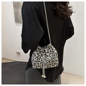 Detail of leopard print bucket bag with silver chain strap and pearl drawstring tassels