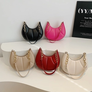 Pleated crescent shoulder bags in multiple colors with chain straps on white display