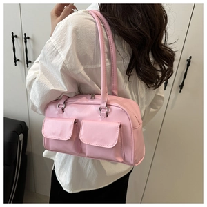 Close-up of pink synthetic leather underarm bag featuring dual front pockets and silver hardware