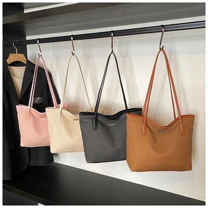 Hanging display of solid-colored PU tote bags in four colors with textured finish