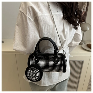 Détail du sac boston noir avec clous argentés et bandoulière en chaîne