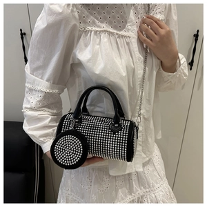 Détail du sac Boston noir avec clous argentés, bandoulière chaîne et petit porte-monnaie
