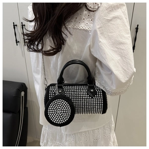 Détail du sac polochon noir à clous avec bandoulière chaîne et mini porte-monnaie