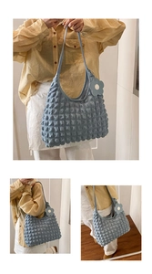 Macro detail of light blue bubble texture fabric with a cute floral bag charm