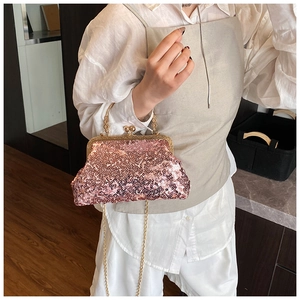 Detail of vintage sequin shell bag featuring gold ball lock and woven metal handle