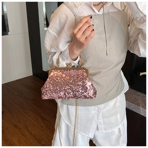 Detail of pink sequin evening clutch bag with ornate gold handle and metallic chain strap