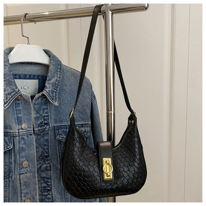 Close-up of black woven hobo bag featuring a decorative golden twist lock and textured finish