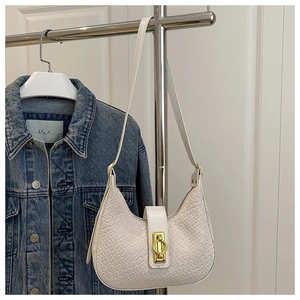 Close-up of white woven leather hobo bag with a gold ring clasp and adjustable strap