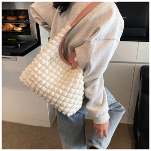 Detail of white textured bubble cloud bag with pink leather strap in kitchen setting